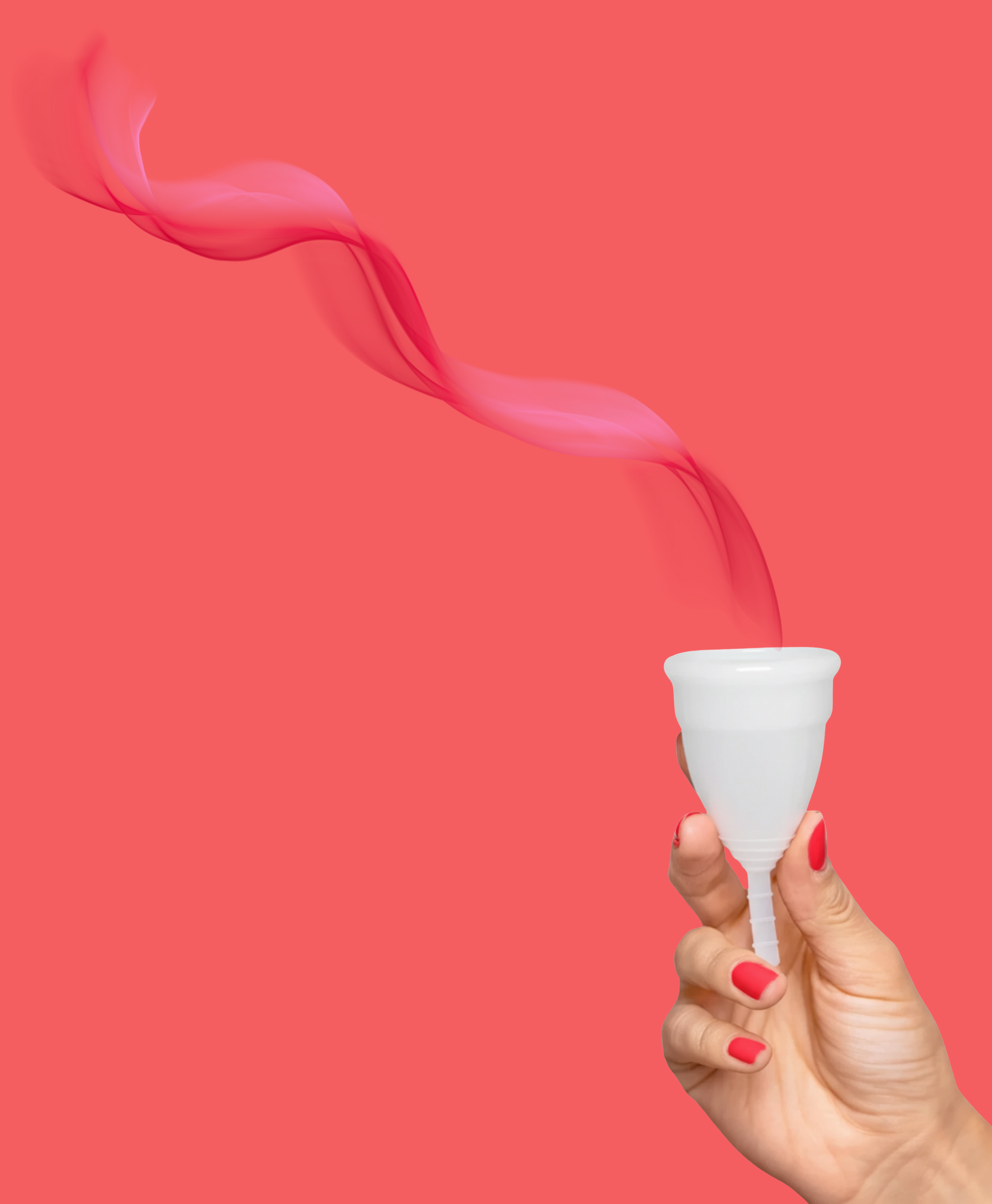 Menstrual cup held in hand against coral